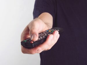 Hand mit Fernbedienung